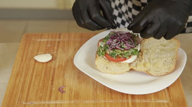 Chef prepares a fresh Mediterranean ciabatta sandwich