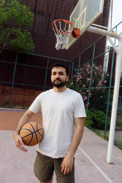 A portrait of a young man on a basketball court.