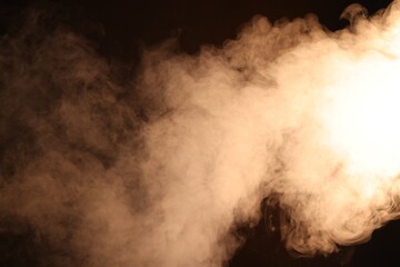 Naklejka premium Beautiful smoke in neon light on dark background
