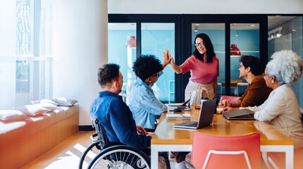 Obraz premium Diverse business team celebrating success with high five in modern office, inclusive workplace culture concept