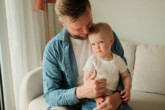 Portrait of happy smiling father hugging his little baby girl at home