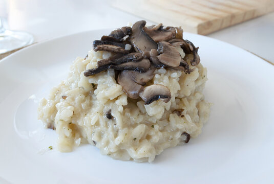 Risotto cremoso con champi&ntilde;ones frescos servido en plato plano