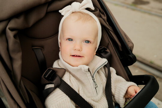 Closeup portrait of little child girl sitting in the stroller