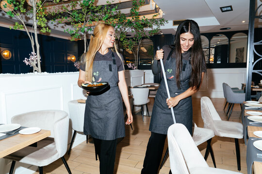 Restaurant waitstaff team working and cleaning dining room