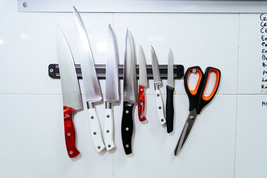 Kitchen knives and scissors hanging on magnetic holder