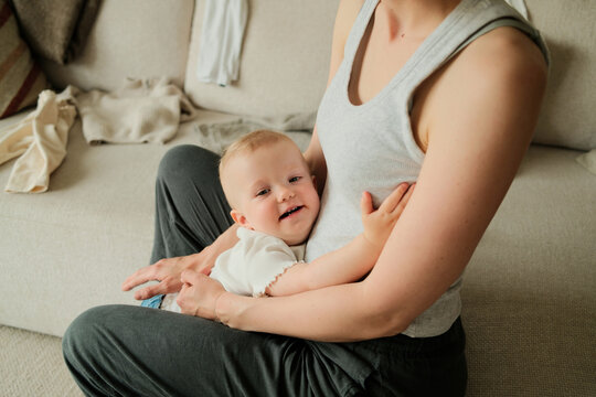 Anonymous mother hugging her baby daughter at home while getting ready