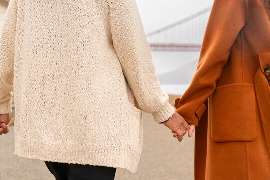 two anonymous women holding hands 