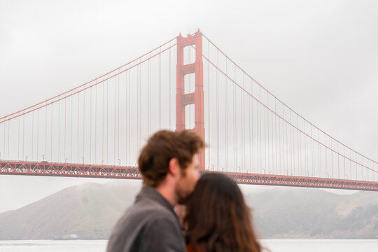 man kisses womans head couple golden gate bridge san francisco 
