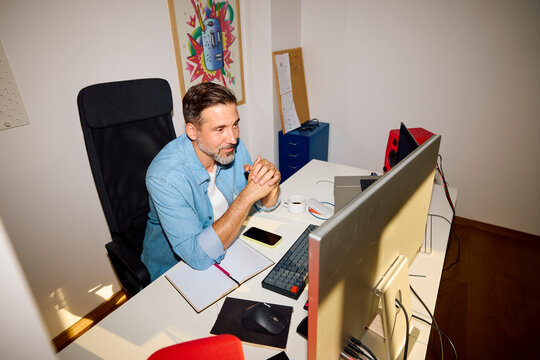 Man works at a desk in the home office.