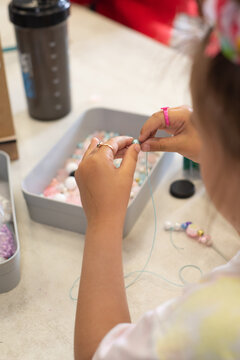 Child stringing beads on a thread. Fine motor skills and development