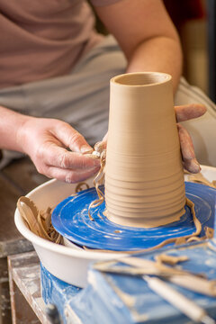 Male hands working with clay on a potter's wheel