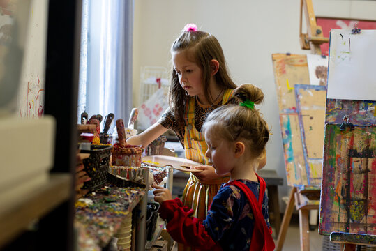 Little child in art school works with paints