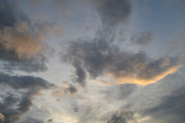Obraz premium Evening Sky with Partially Overcast Clouds, Golden Glow from Setting Sun, Darker Cloud Masses Above