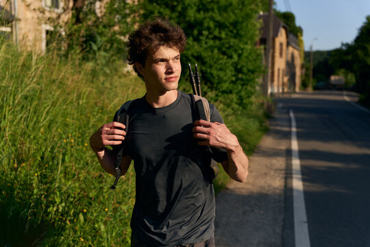 Hiker Walks Along a Quiet Road in the Countryside