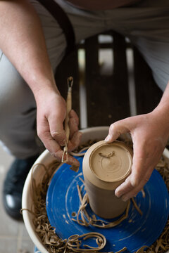 Male hands working with clay on a potter's wheel