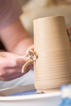 Male hands working with clay on a potter's wheel