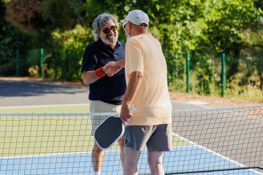 Senior players shaking hands after pickleball game