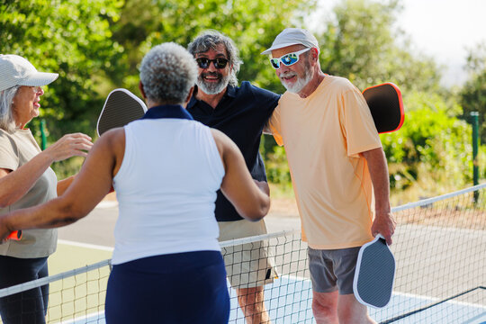 Senior friends enjoying pickleball game on court