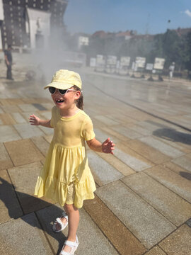 Girl being sprayed with water on a hot day
