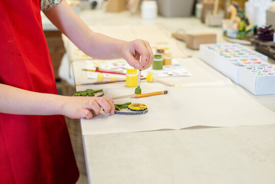 Small child stamps a print on fabric with paints
