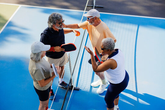 Seniors enjoying fun pickleball game on court