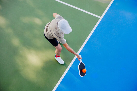 Active woman playing pickleball on court