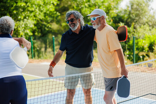 Senior friends enjoying pickleball game outdoors