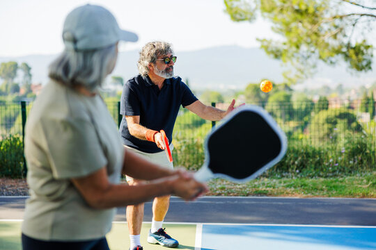 Seniors playing pickleball outdoors enjoying active lifestyle
