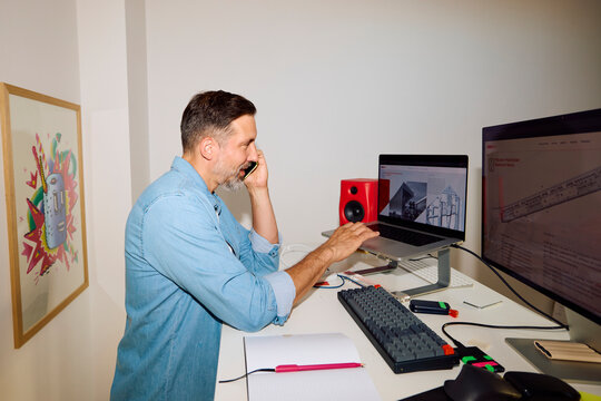 Man works at a desk in the home office.