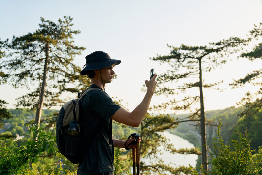 Hiker Takes Picture Near River in Nature During Sunny Day