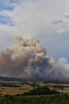 Massive Wildfire Smoke Plume Over Rural Landscape