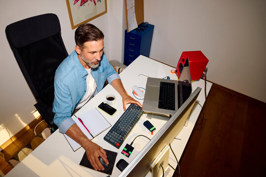 Man works at a desk in the home office.