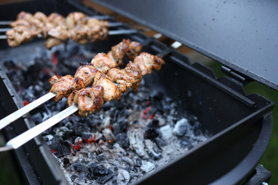 A man is preparing food on the grill.