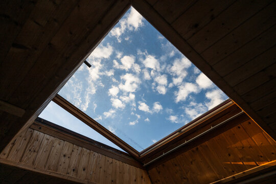Open Skylight Framing Blue Sky and White Clouds