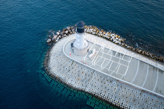 
Lustica bay lighthouse on breakwater, aerial view