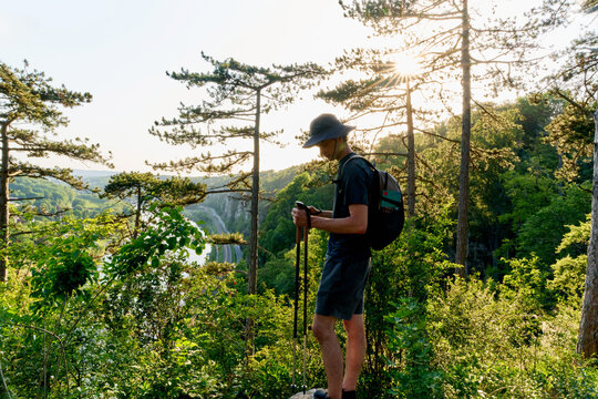 Hiker Stands on a Rock Looking at River  in Nature