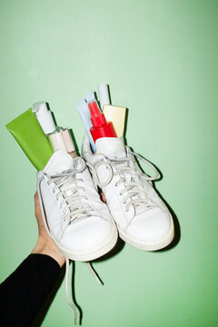 White fashion style sneakers full of cosmetic beauty makeup products 