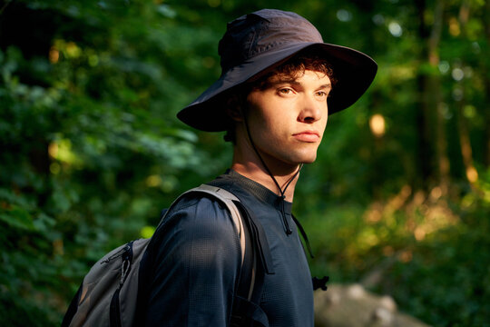 Young Man Hiking in Forest With Backpack During the Day