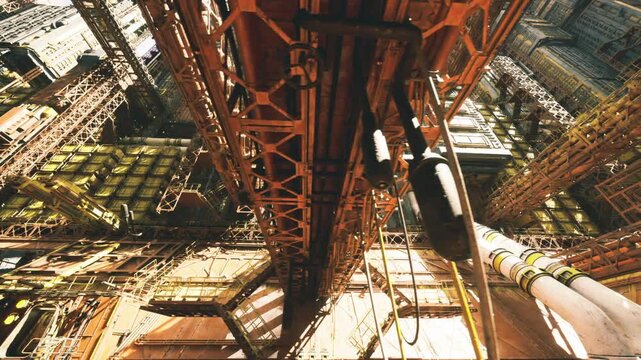 Upward rig perspective through lattice beams, dense cluster of pipes and platforms, bright highlights and deep crevices, sense of scale and industrial