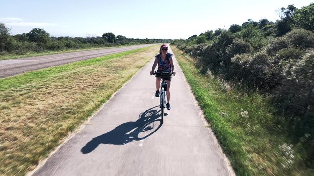 Woman cycling through Dutch countryside
