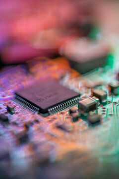 Computer microchip on circuit board with colorful bokeh