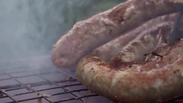 Macro closeup coiled sausage on grill, metal tongs press coil, juices bubble and pop, sear marks deepen, smoke rises from glowing charcoal embers, backyard chef flips coil, street vendor and pitmaster