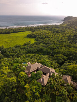 Aerial view of a luxury villa nestled in a lush tropical jungle overlooking the Pacific Ocean coastline in San Miguel, Provincia de Guanacaste, Costa Rica.
