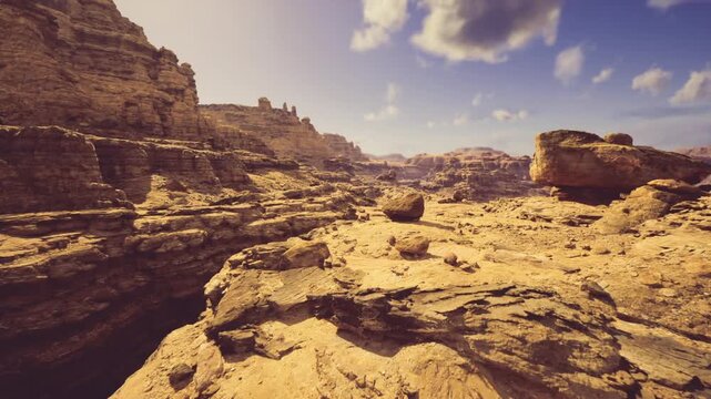 lateafternoon gorge rim bathed in warm light revealing steep chasm layered ledges scattered rock formations expansive sky and long dramatic shadows perfect