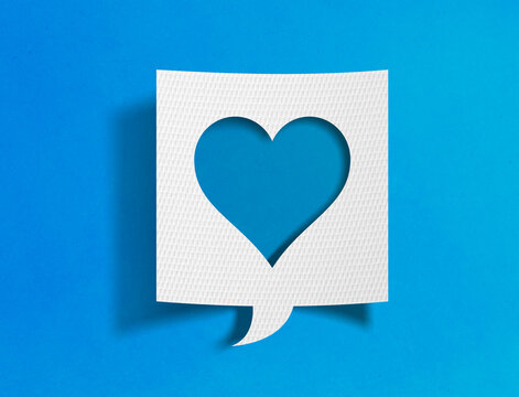 Heart speech bubble on blue background with paper cutout design