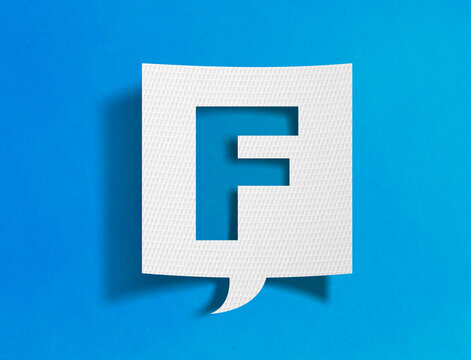 Letter F speech bubble on blue background with paper cutout design