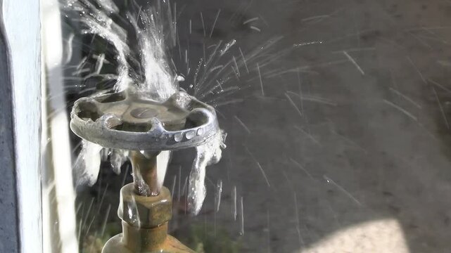 Water leaking heavily from worn out faucet or tap, indicating waste of valuable resource. With ambient sound.