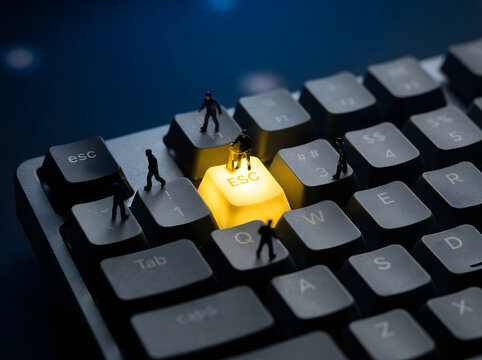 Tiny worker figures standing on backlit computer keyboard focus on glowing yellow escape button representing corporate exit.