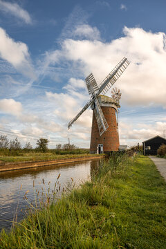 Horsey Windpump beside Norfolk Broads waterway beneath a dramatic autumn sky