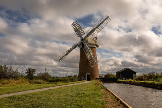 Horsey Windpump beside Norfolk Broads waterway beneath a dramatic autumn sky